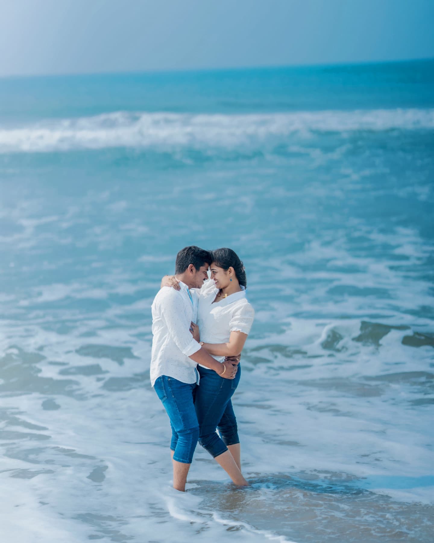 Couple embracing in the waves on the beach