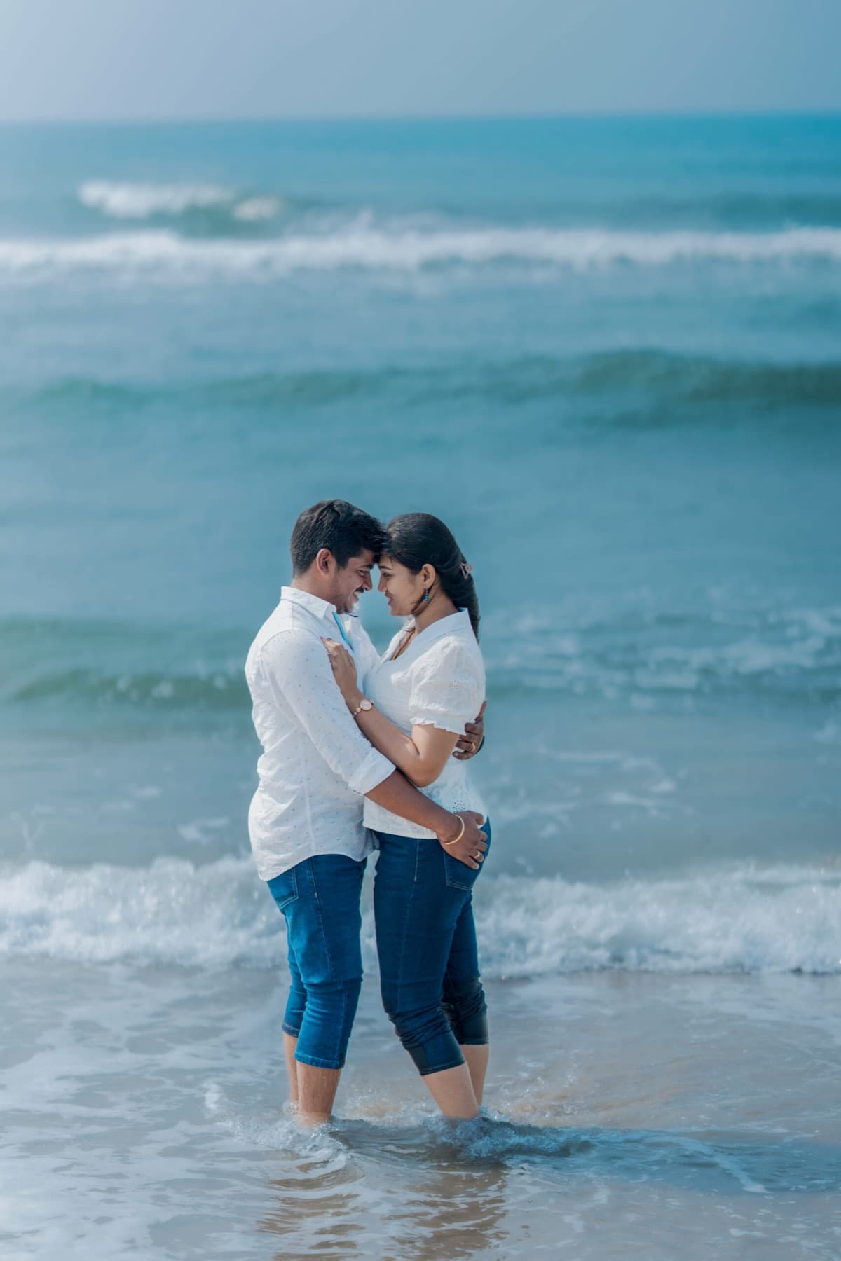 Couple standing together in the waves