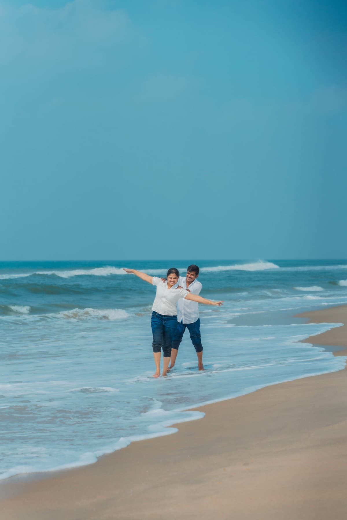 Couple walking along the beach shore