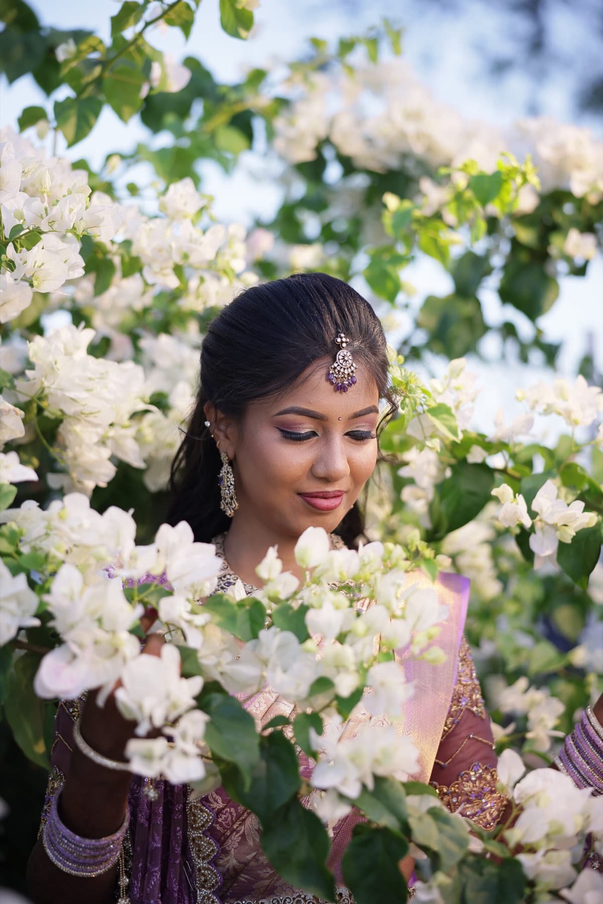 Bride surrounded by white bougainvillea flowers