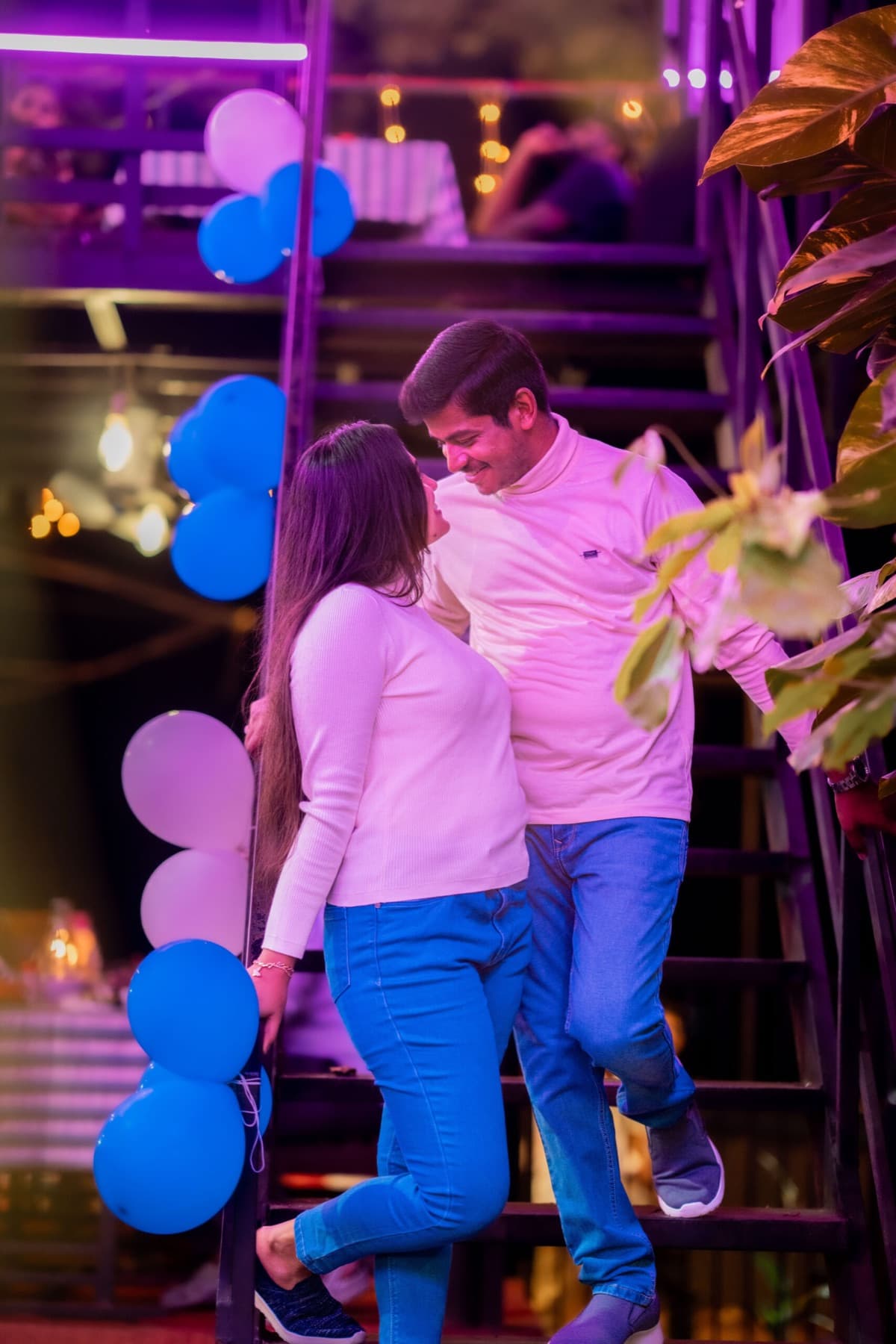 Couple on cafe stairs decorated with balloons