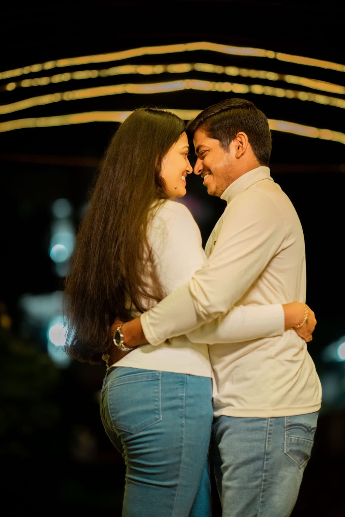 Couple embracing under warm fairy lights