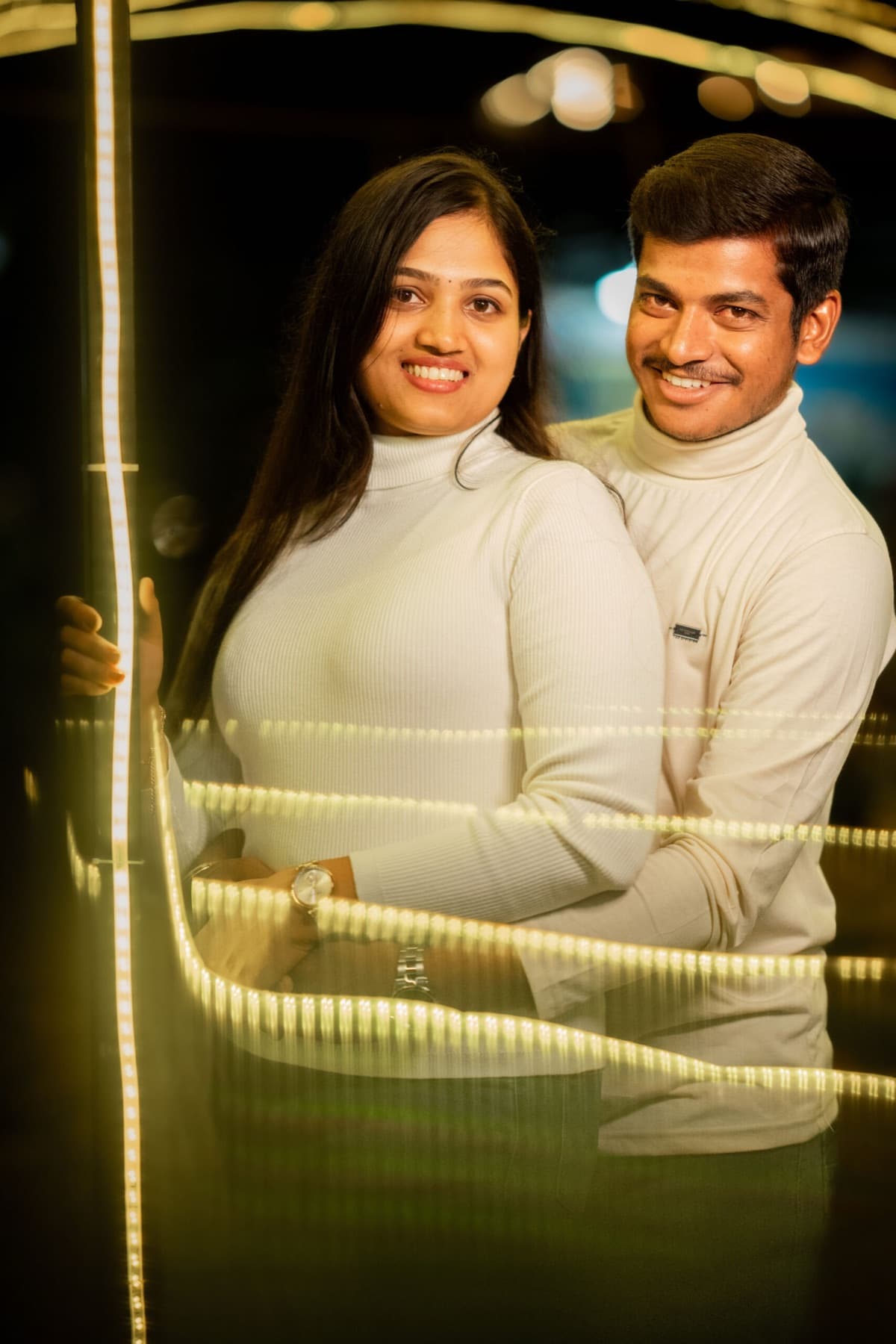 Night portrait of a couple with string lights