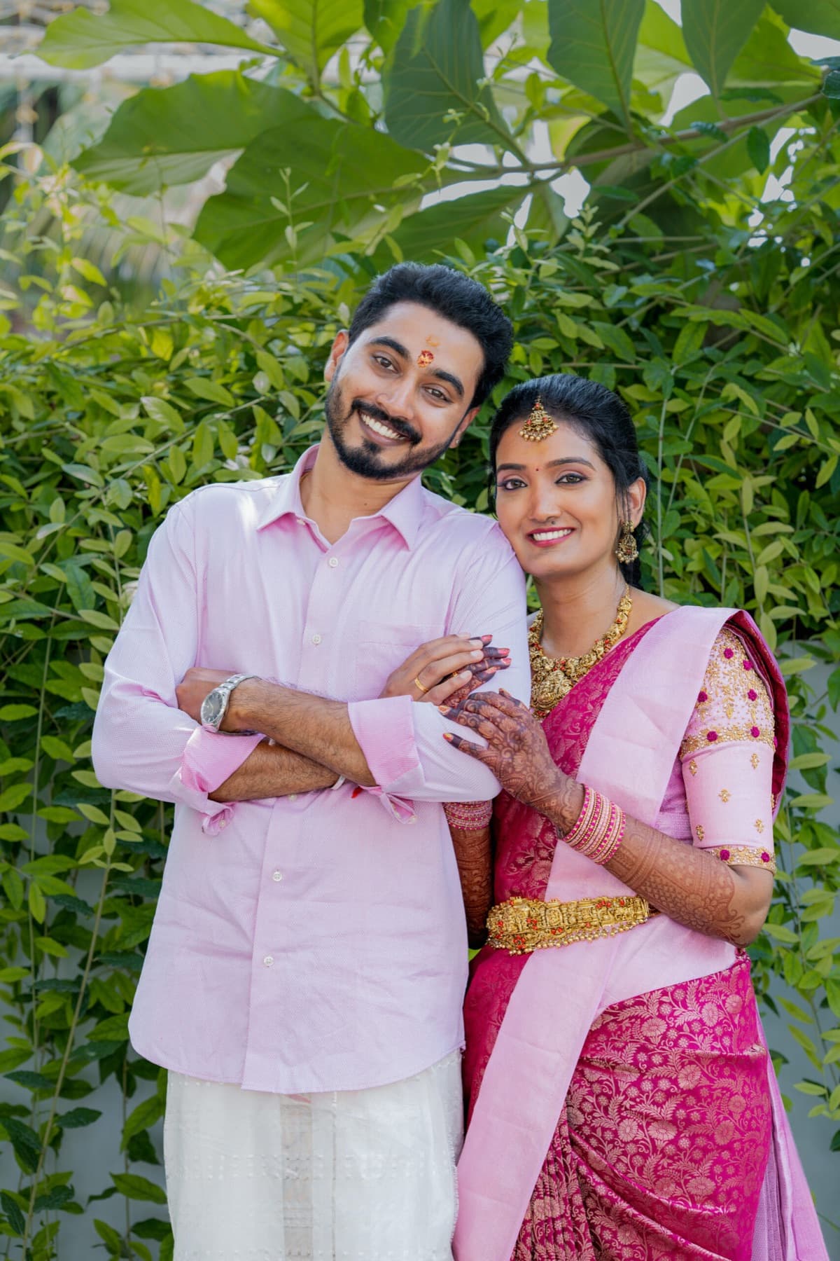 Smiling couple in matching pink traditional outfits