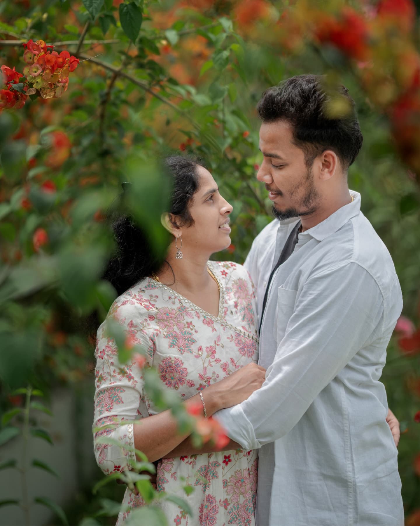 Couple portrait among bright red flowers