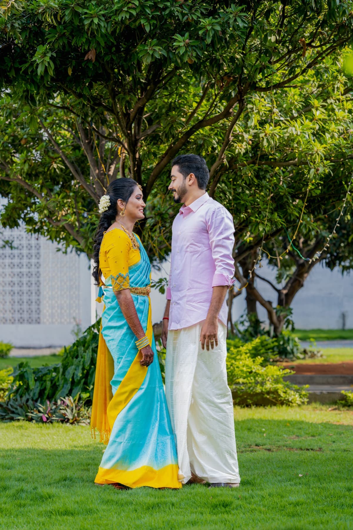 Couple in a silk saree and veshti posing in a garden