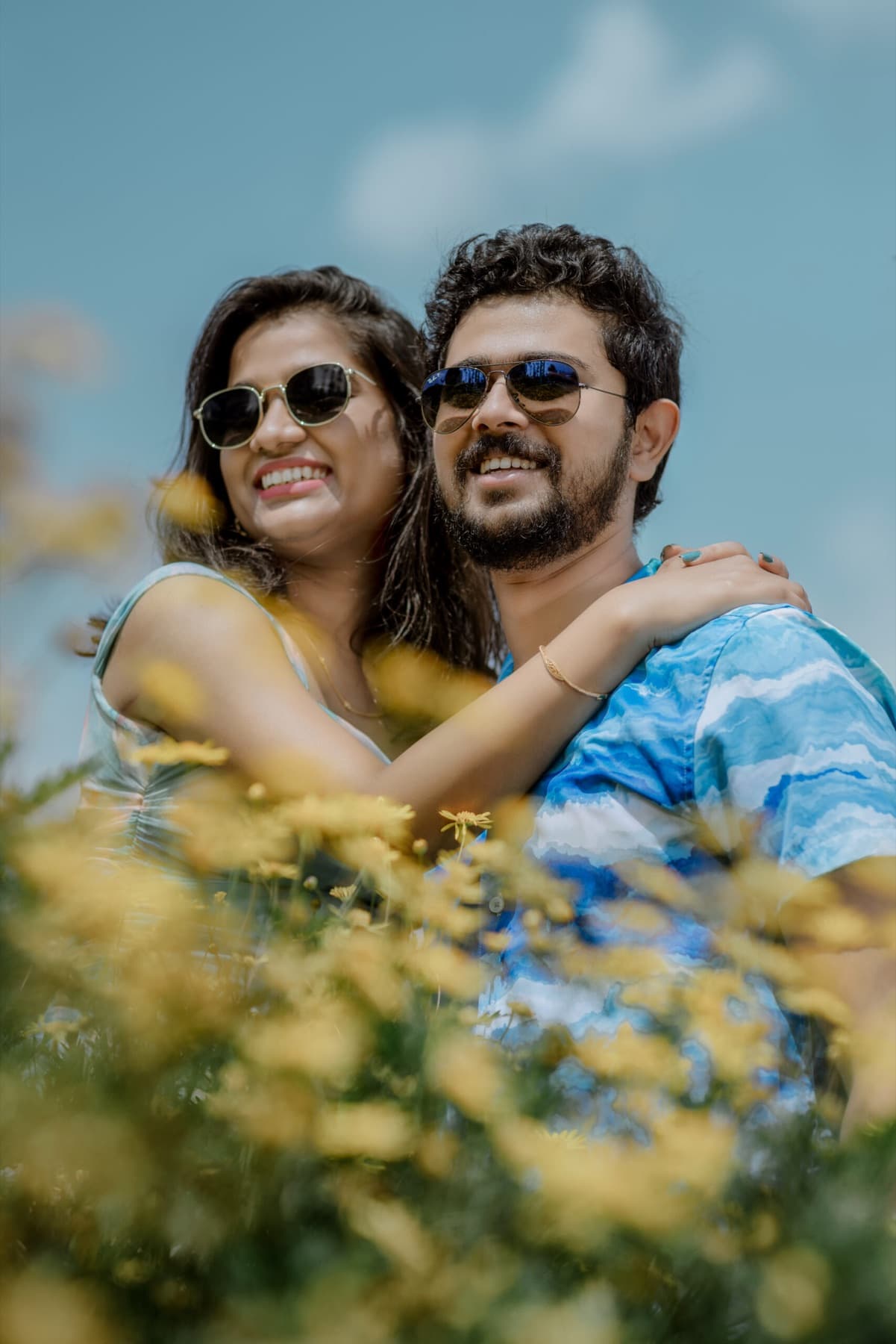 Couple in sunglasses among yellow flowers