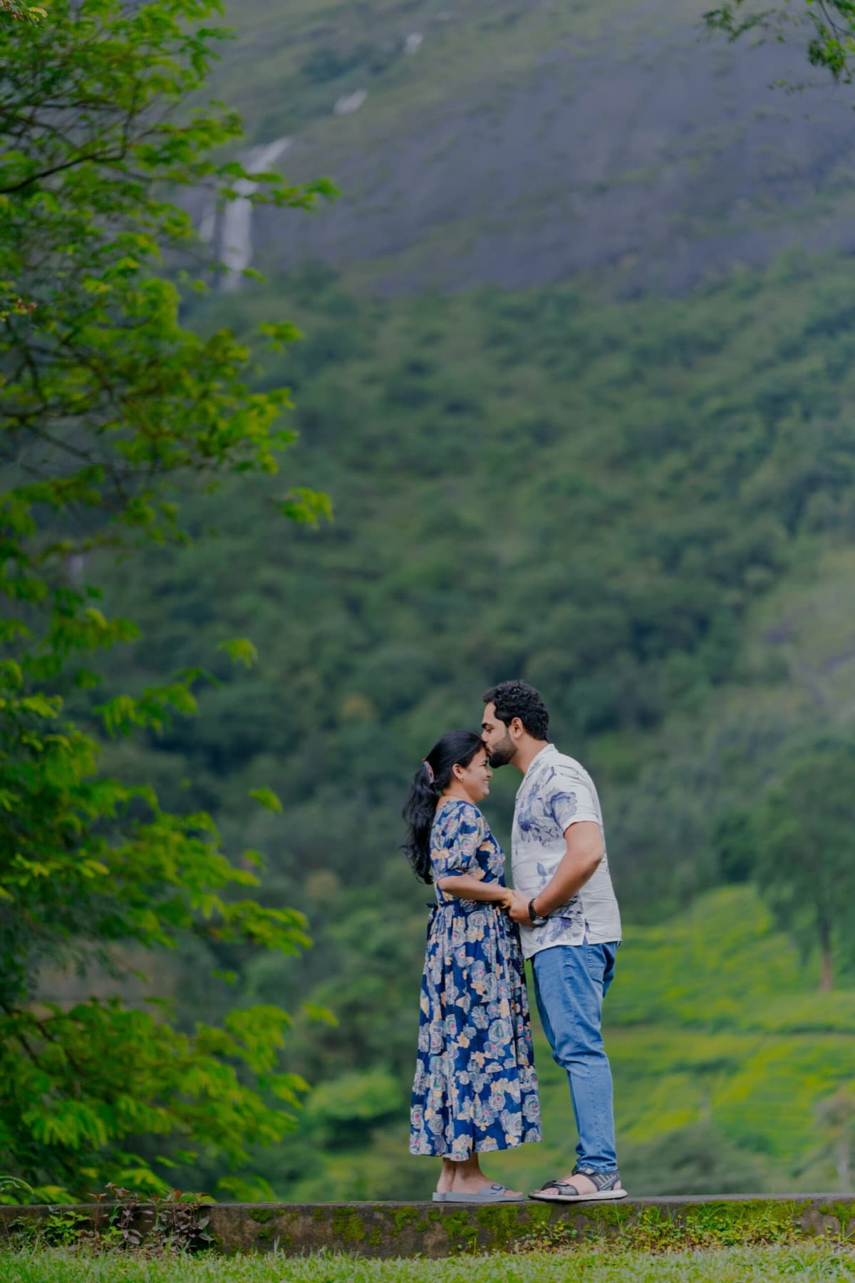 Couple embracing against misty hills during a pre-wedding shoot