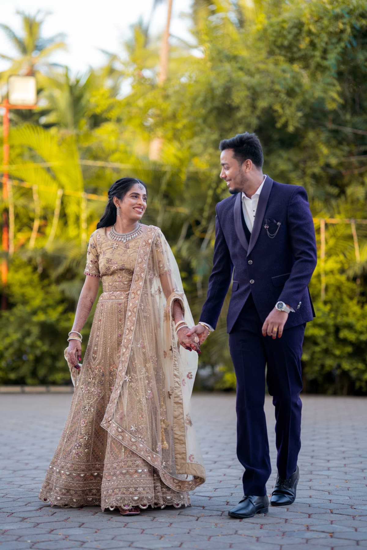 Couple walking hand in hand in reception outfits