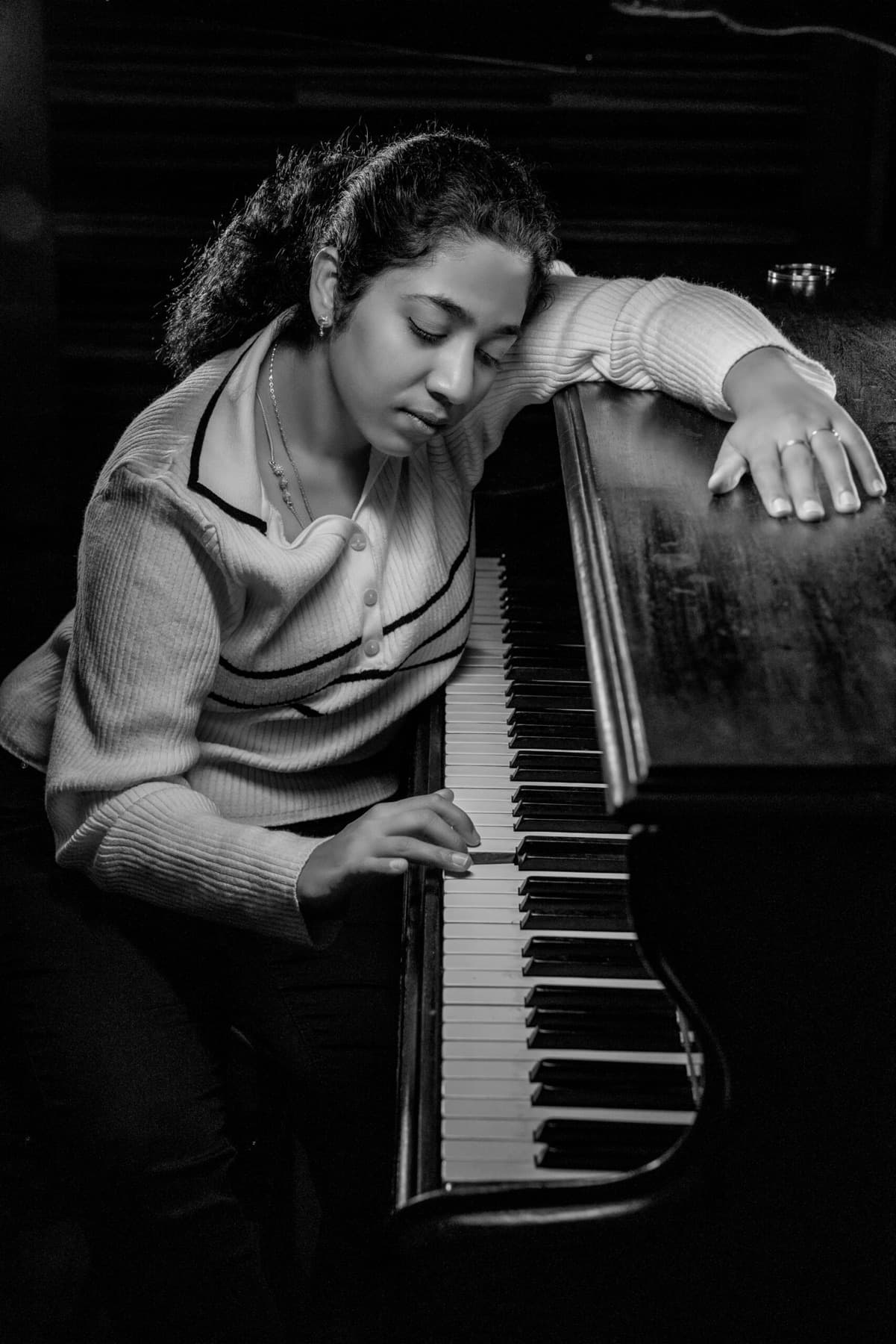Black and white portrait of a woman playing the piano