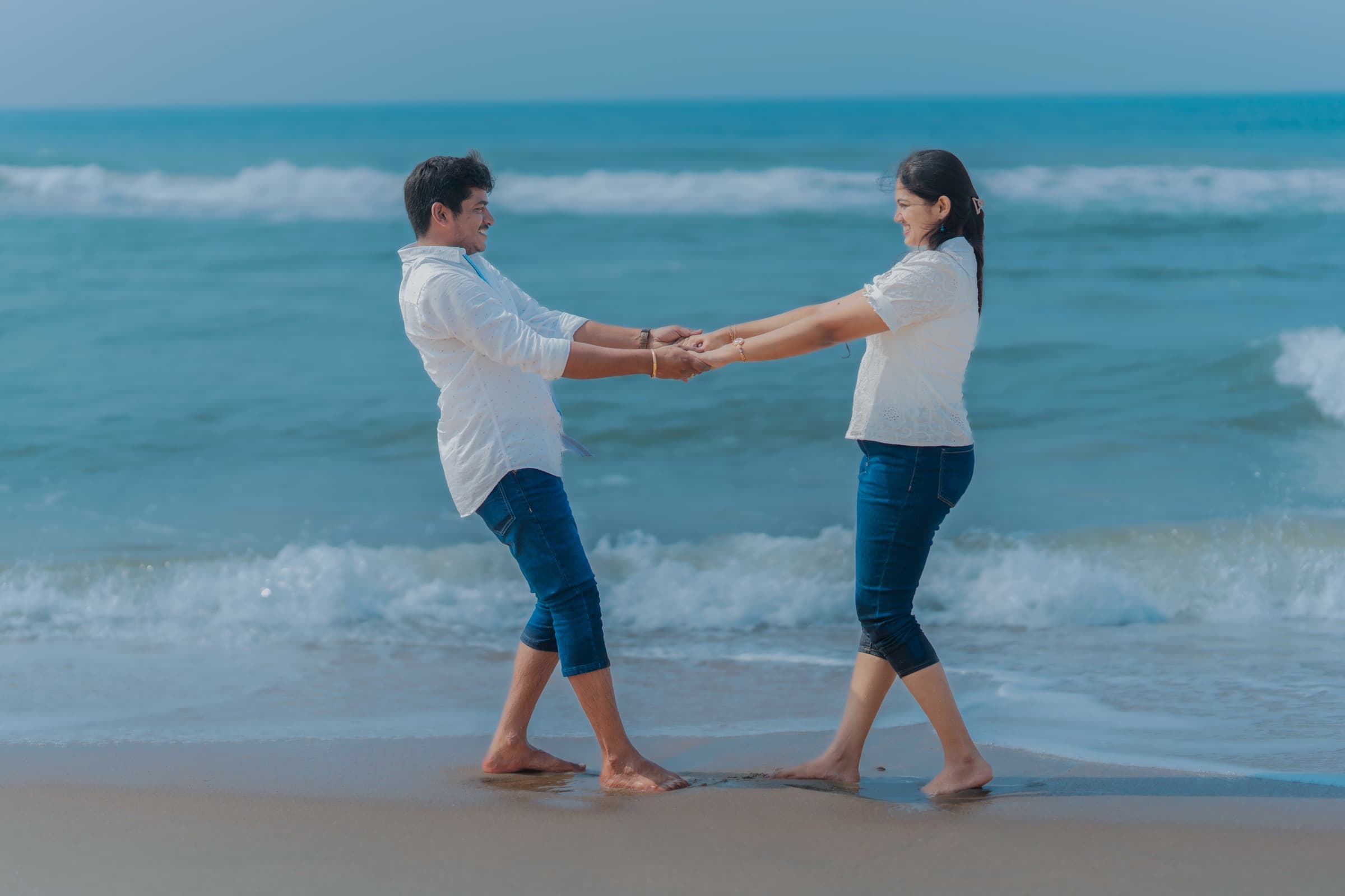 Couple holding hands on the beach during a pre-wedding shoot