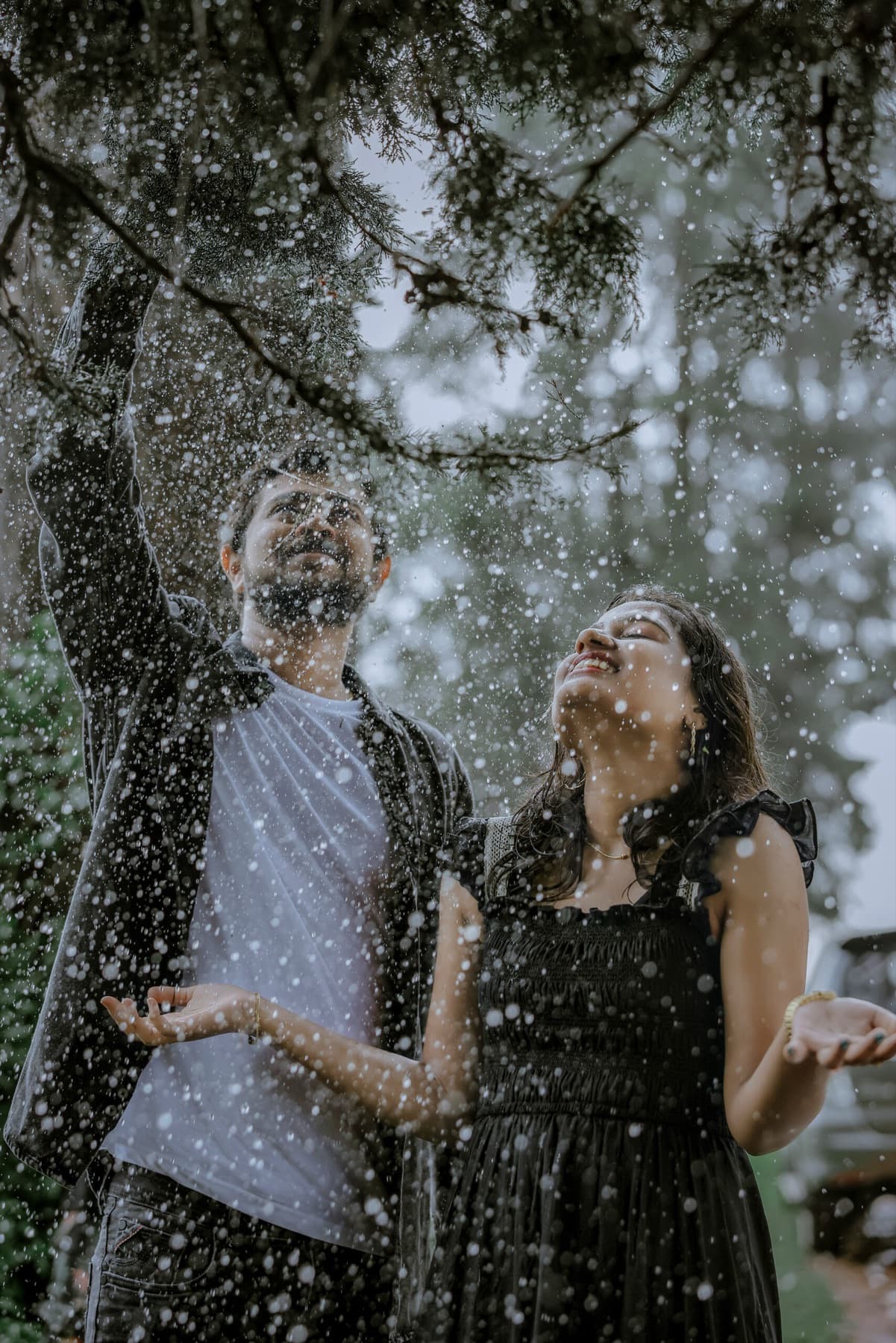 Couple laughing in the rain during a pre-wedding shoot