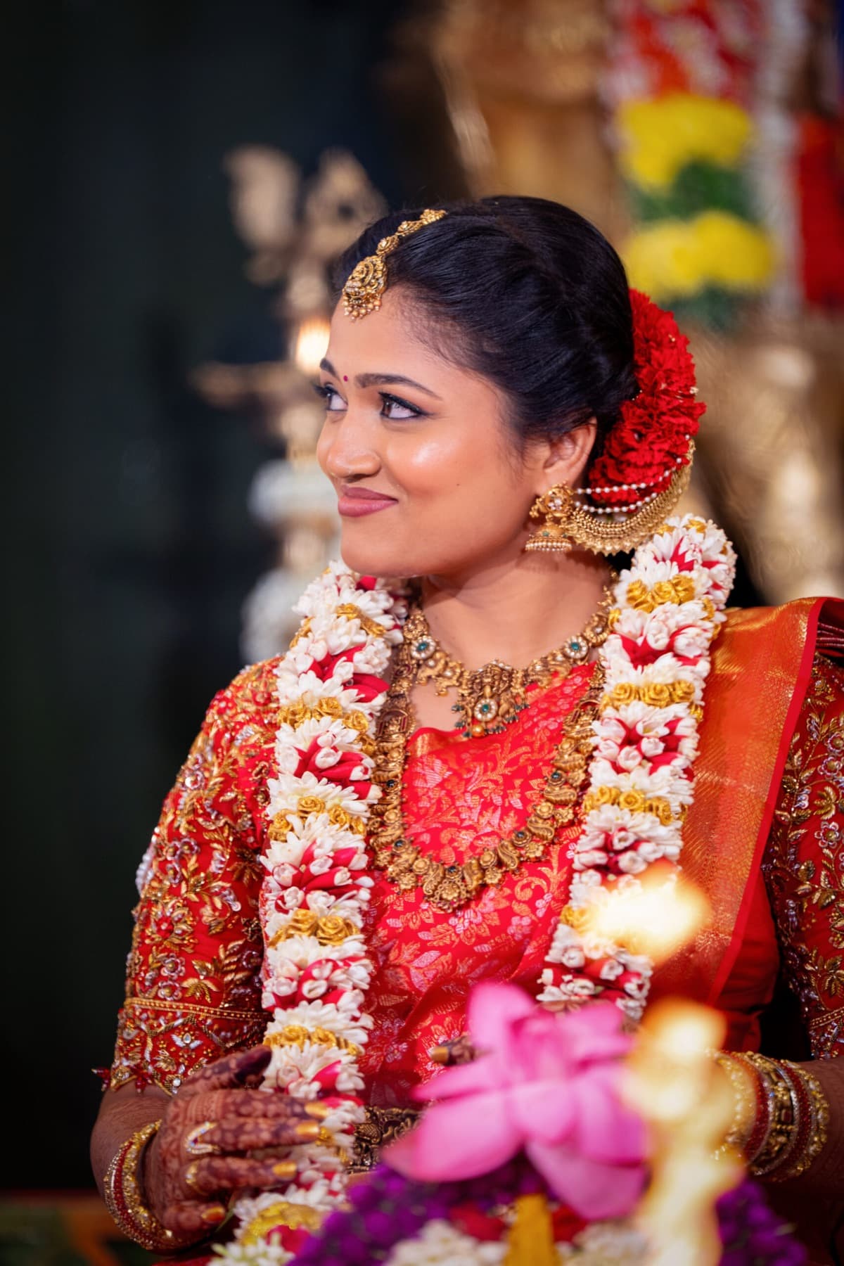Tamil bride in a red silk saree with a flower garland, traditional wedding portrait