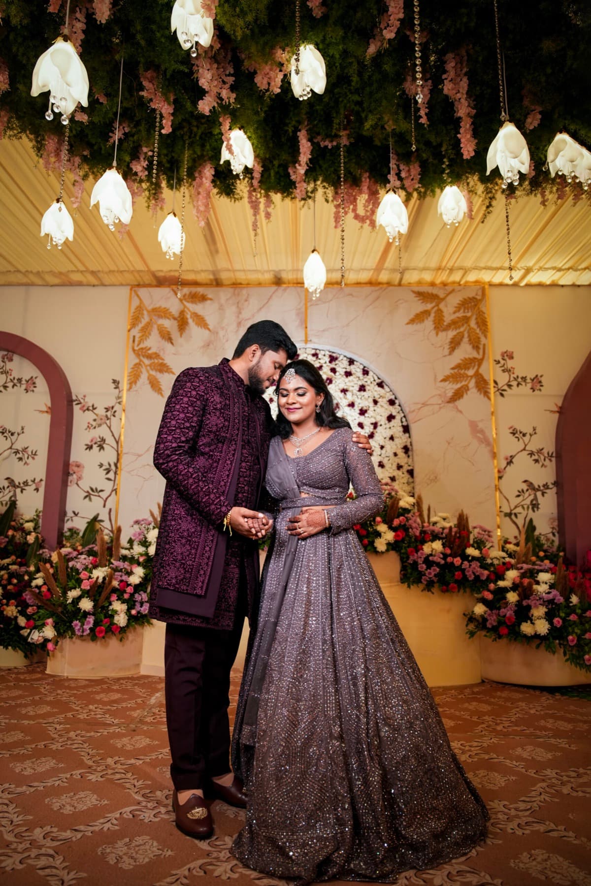 Couple on a floral stage at their wedding reception in Coimbatore